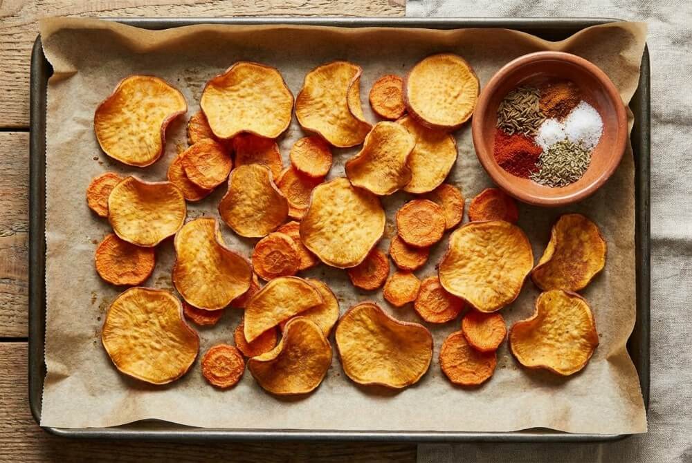 Domowe chipsy z batata i marchewki upieczone na złocisto.