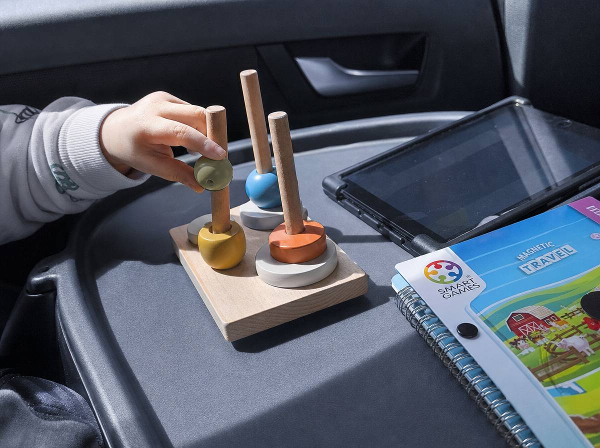Zabawki i tablet z bajkami jako rozrywka dla dziecka podczas podróży